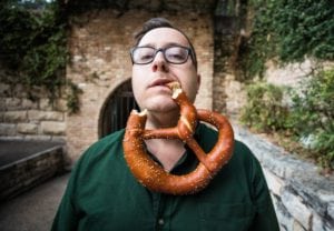 Farley Elliott eats a giant pretzel